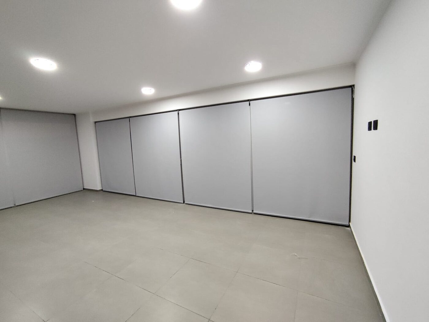 Cortinas roller claras cerradas cubriendo el ventanal de un departamento recién terminado