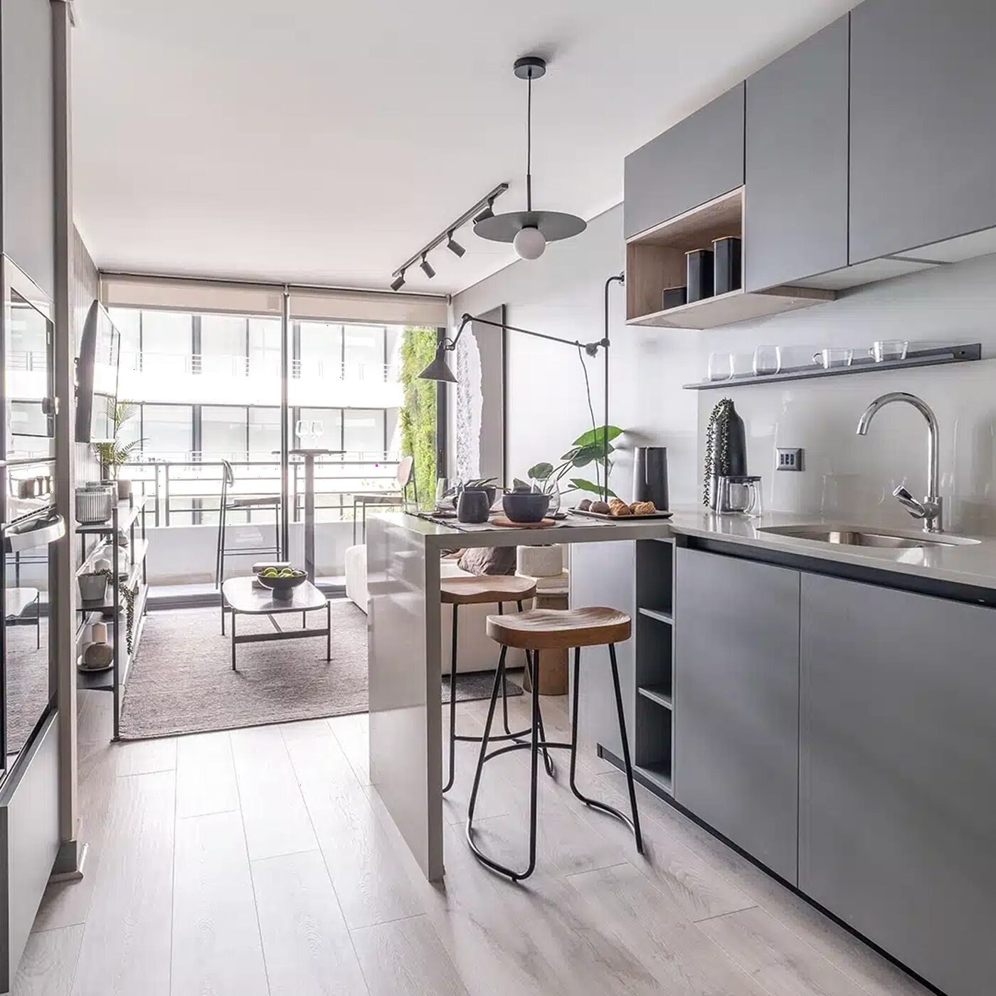 Cocina y living de un departamento con ventanal de piso a techo