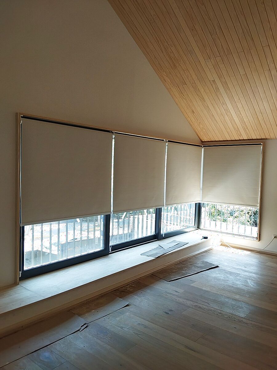 Cortinas roller a medida bajo cielo de madera, instaladas sobre ventanales de terraza