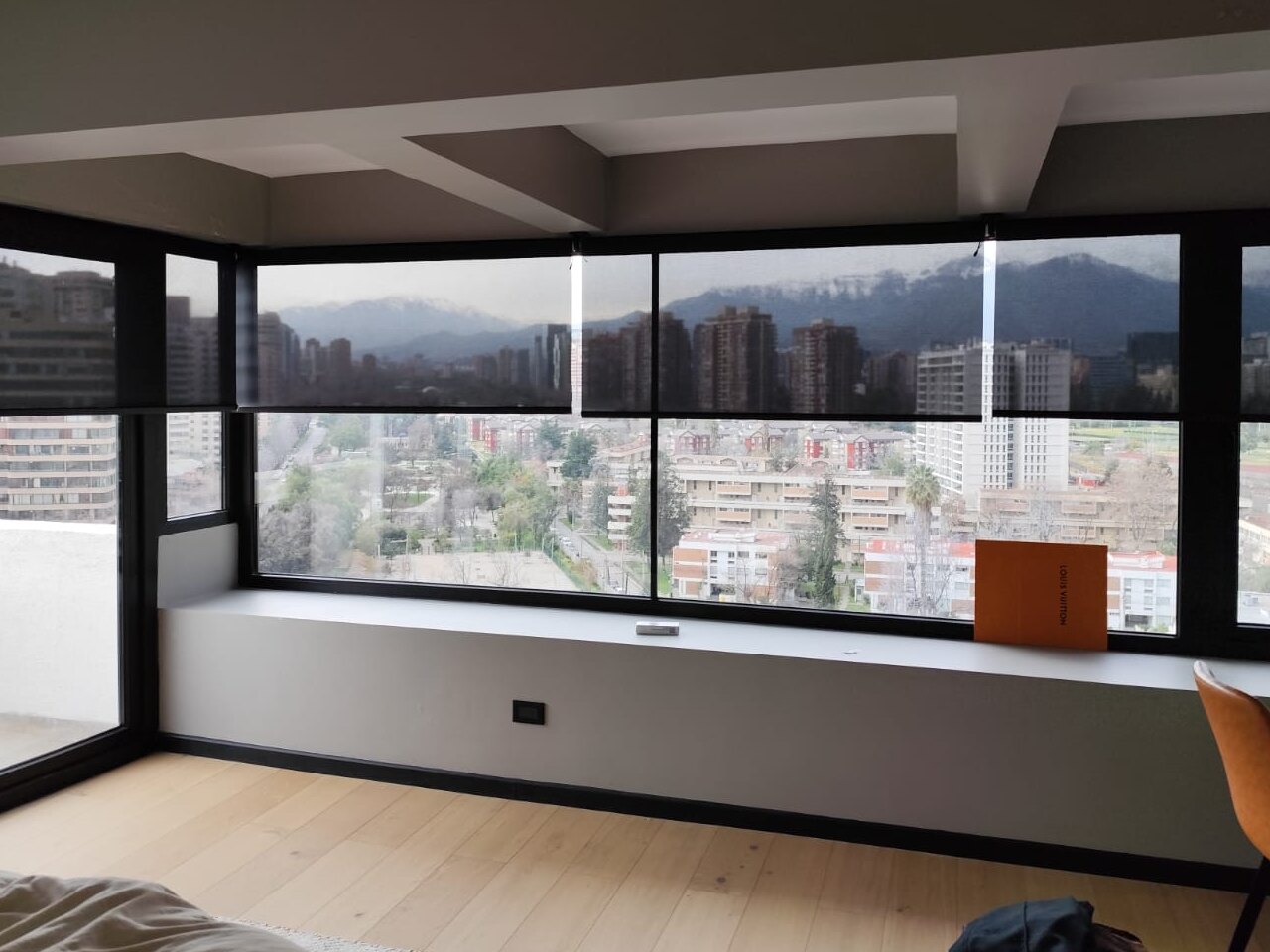 Cortinas roller a medida en las ventanas en esquina de un dormitorio con vista a la cordillera, Santiago